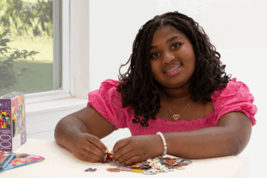 girl completing puzzle at home during summer
