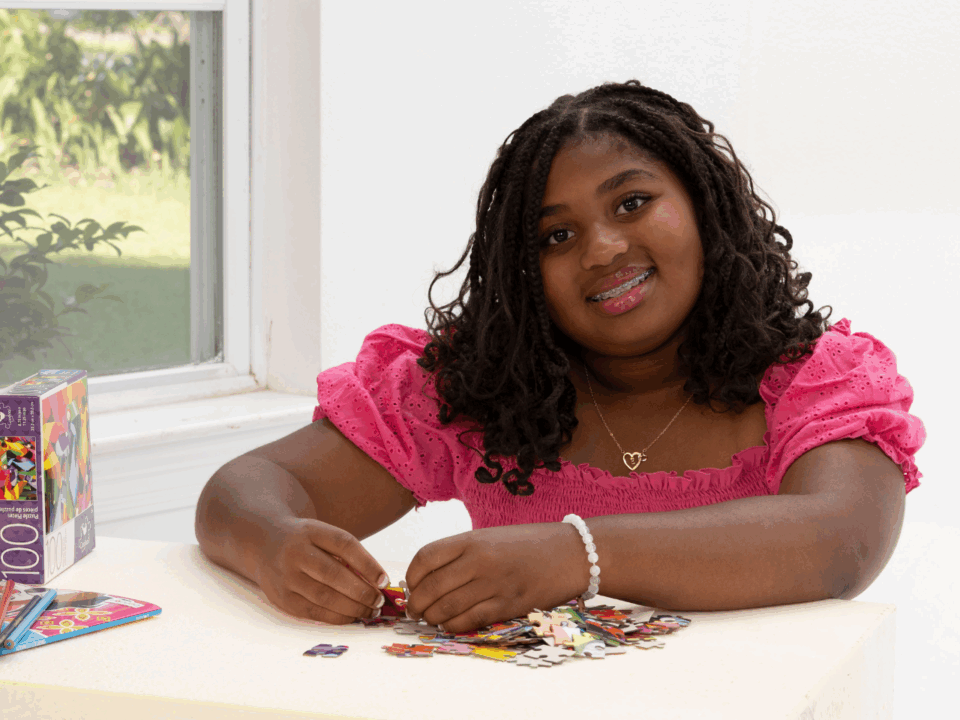 girl completing puzzle at home during summer