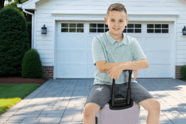 boy sitting on luggage for weekend getaways