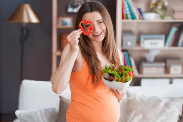 healthy eating; pregnant woman holding vegetable