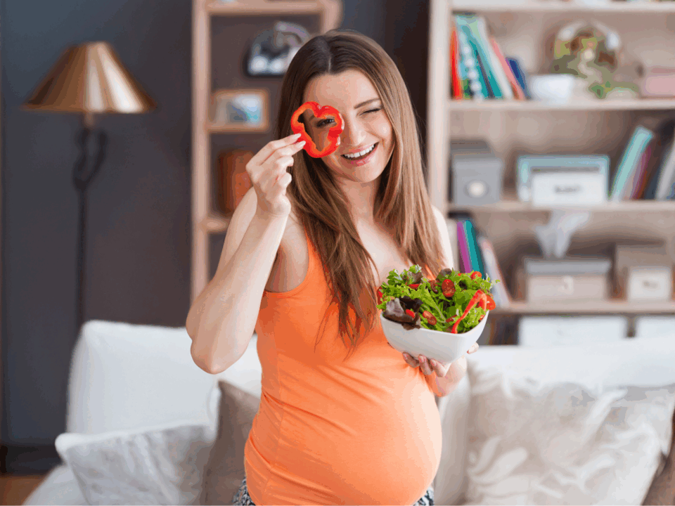 healthy eating; pregnant woman holding vegetable