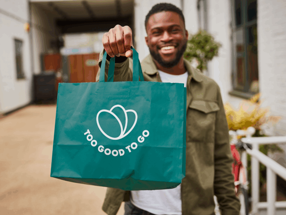 man holding too good to go bag; preventing food waste