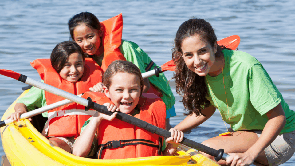 summer camp checklist; kids in canoe at camp