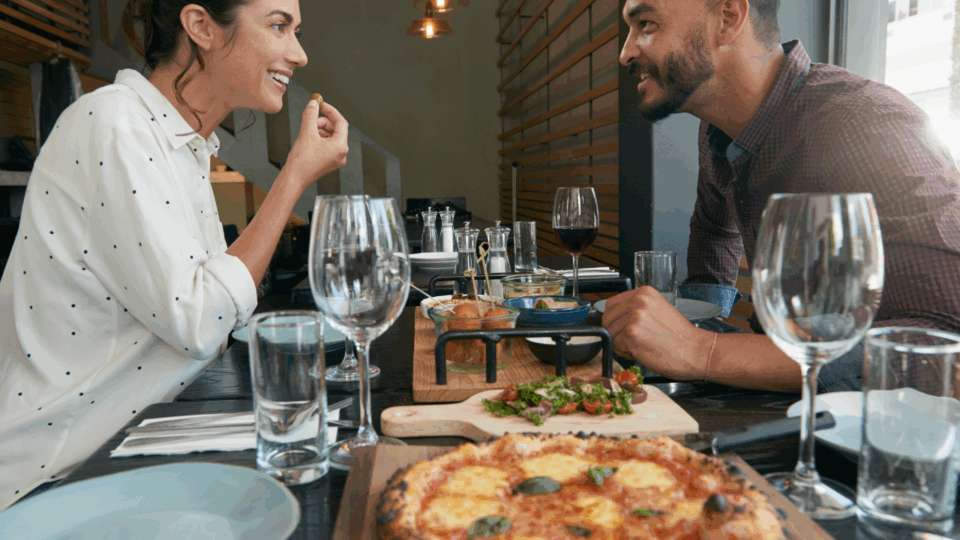 Parents-Only Getaway; a mom and dad on a date eating pizza