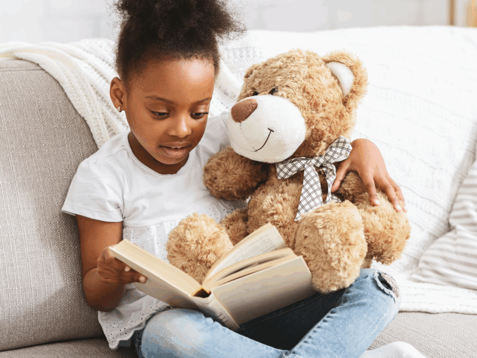 child reading with teddy bear
