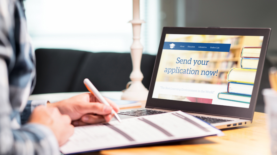 college planning; student sitting at laptop and applying to college