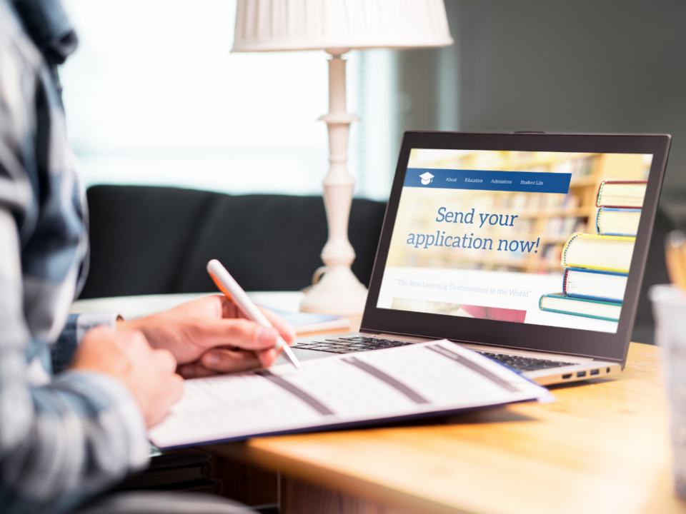 college planning; student sitting at laptop and applying to college