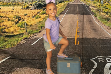 family trips; girl with foot on suitcase on route 66 backdrop