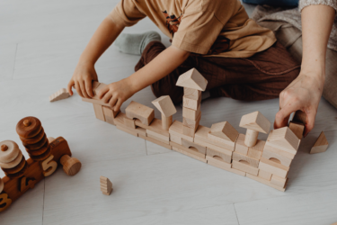 Low-Stimulation Parenting; child and parent playing with wooden blocks