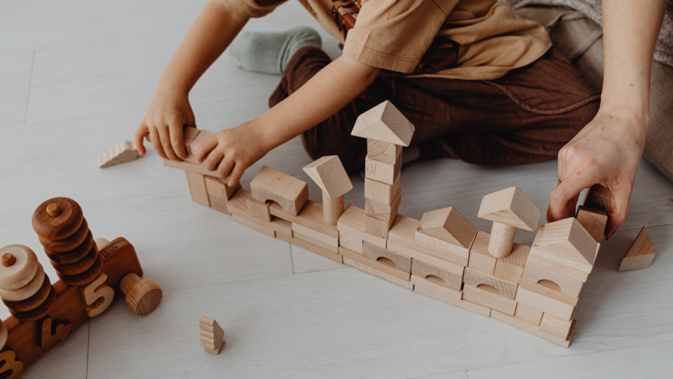 Low-Stimulation Parenting; child and parent playing with wooden blocks