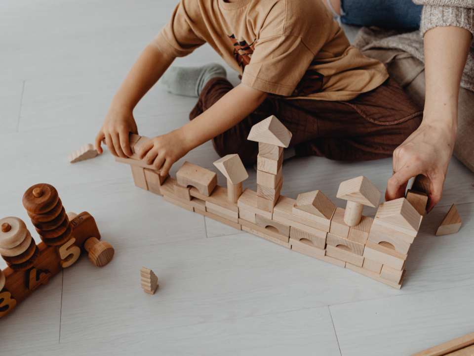 Low-Stimulation Parenting; child and parent playing with wooden blocks