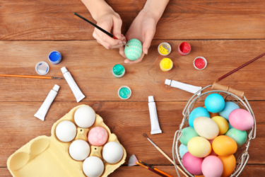 Easter crafts; person decorating an egg using paint