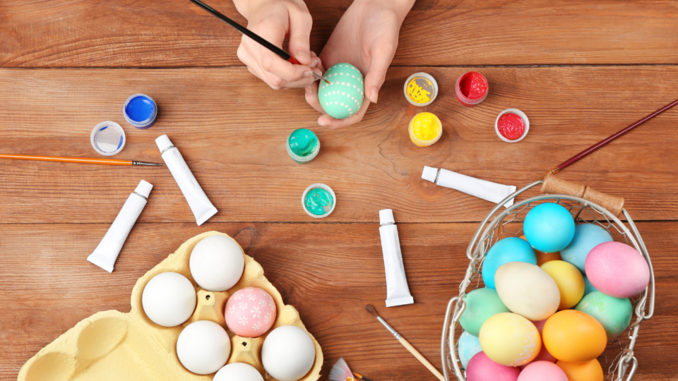 Easter crafts; person decorating an egg using paint