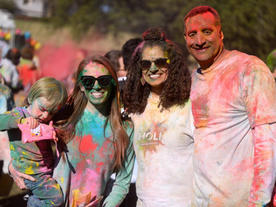family-friendly events; family covered in colorful powders at Holi Festival