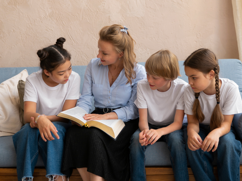 woman and children sitting down reading the Bible; faith