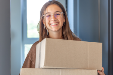 girl carrying boxes; move-in day