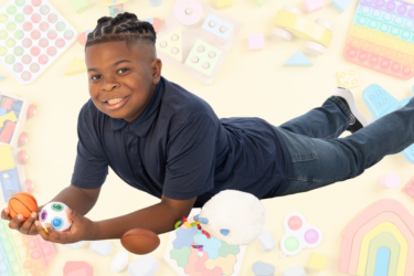 boy laying on floor with fidgets