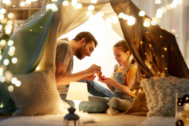 screen-free; dad and child in blanket fort with lights