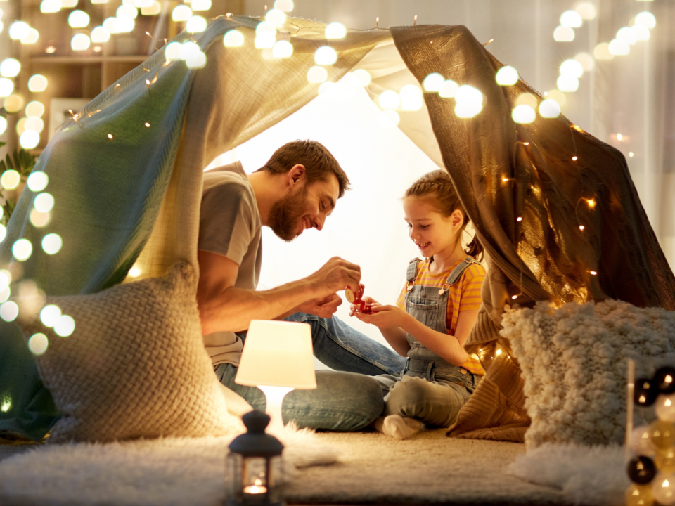 screen-free; dad and child in blanket fort with lights